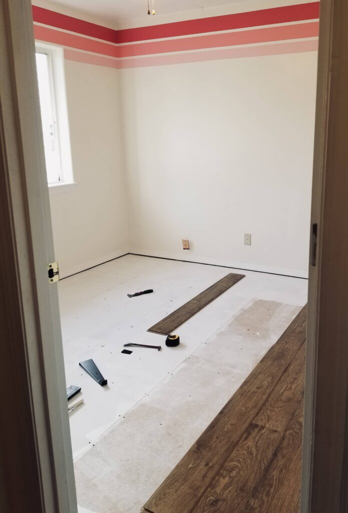 laminate installation in the kids room with pink stripes