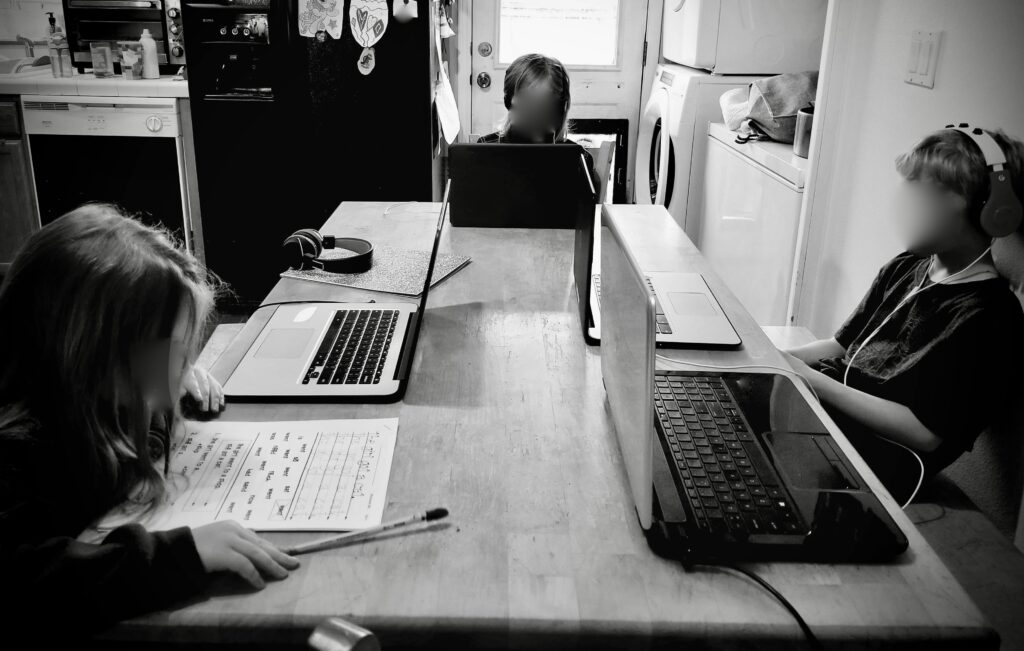 three children on computers doing distance learning during Covid19 quarantine