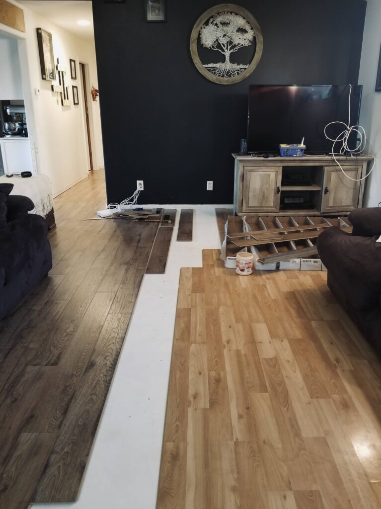 new darker laminate is being instaled in the living room next to older lighter laminate