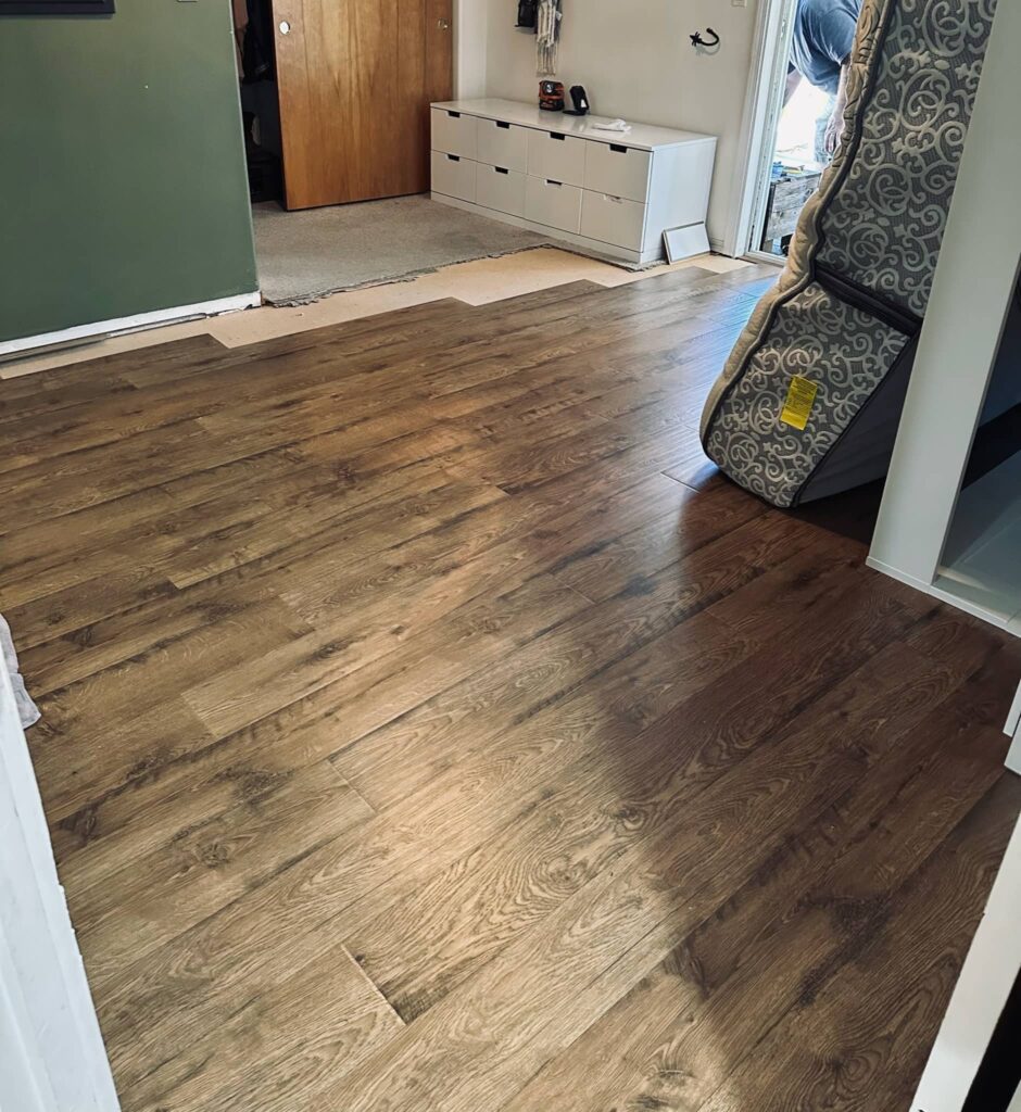 newly installed laminate floor showing up to last of old carpet to be removed