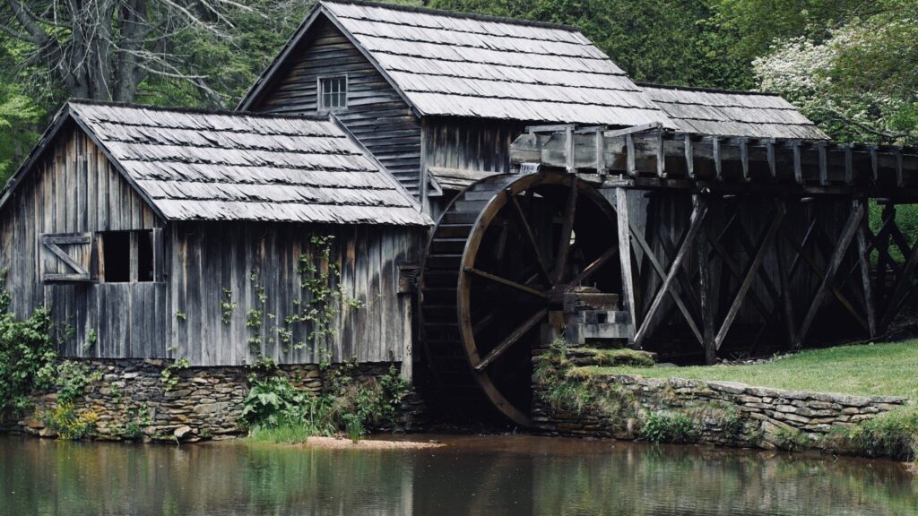 what is it you truly want - Showing an old mill with a wooden water wheel situated in the forest next to a river