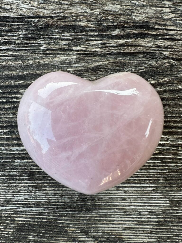 Who are your body parts - A polished rose quartz stone in the shape of a heart with a barn wood background.