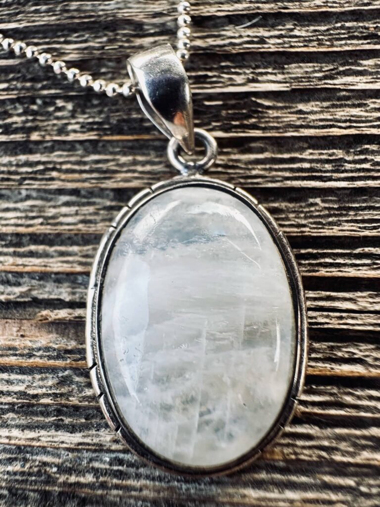 Who are your body parts - Oval moonstone pendant set in sterling silver lying on old barn wood