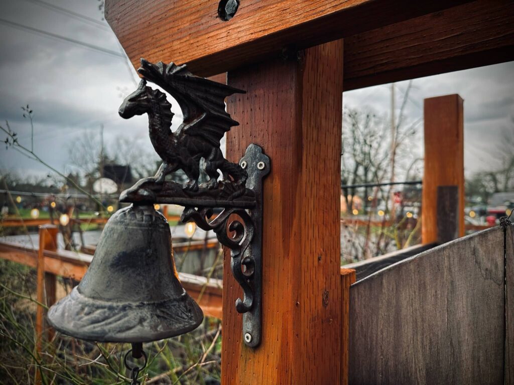 Cast iron dragon bell on Cast iron dragon bell on Sue Evergreen's garden gate. Representing the year of the dragon. Remembering life's magic.