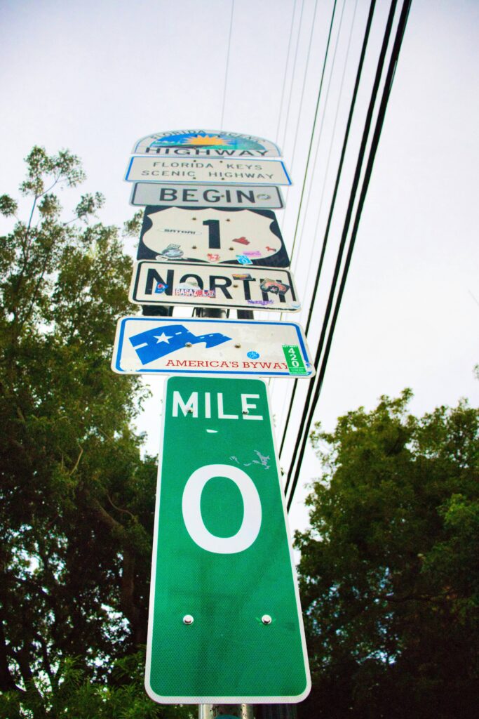 A pole with road signs for North 1 and mile 0. Photo by Paws and Prints on Unsplash.